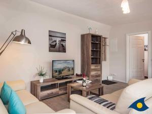 a living room with a couch and a tv at Villa Livia Whg 13 in Ahlbeck +11 photos