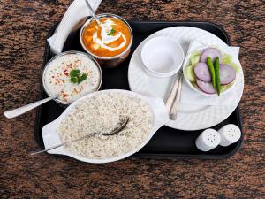 a tray of food with rice and vegetables and dip at Kamaksha Palace in Sundarnagar