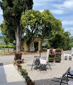 a garden with chairs and flowers and a tree at Garda Havens in Castelnuovo del Garda
