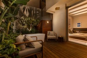 a room with plants and a bed and a tub at The ABY in Tel Aviv