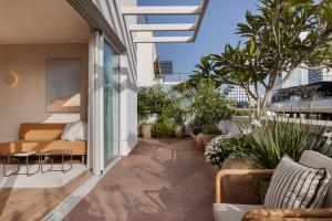 a balcony with plants and a couch on a building at The ABY in Tel Aviv