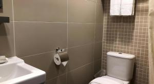 a bathroom with a toilet and a sink at WE Hotel Kowloon in Hong Kong