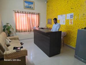 a man standing at a counter in a room at Hotel MNP in Jabalpur