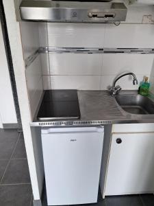a small kitchen with a sink and a stove at STUDIO COSY PROCHE PLAGE, tout à pied in Pornichet