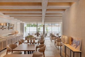 a restaurant with tables and chairs and windows at The ABY in Tel Aviv