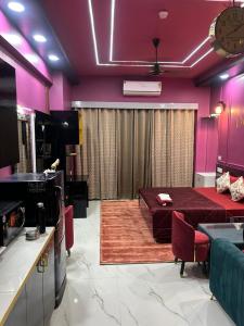 a living room with purple walls and a table and chairs at THE MOONLIGHT STUDIo in Ghaziabad
