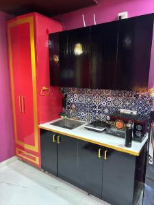 a kitchen with a sink and a red cabinet at THE MOONLIGHT STUDIo in Ghaziabad