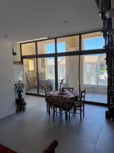 a dining room with a table and chairs and large windows at Charming loft in Cozzano in Cozzano