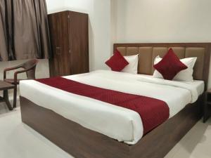 a bedroom with a large bed with red pillows at Shubham Resort in Bhilwara