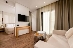 a living room with a couch and a tv at Mary Hotel in Limenas
