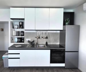 a kitchen with white cabinets and a sink at Apartman Buba in Jesenice +24 photos