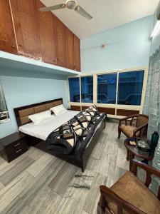 a bedroom with a bed and a table and some windows at RAMRAJ GUEST House in Ayodhya