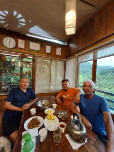 a group of men sitting around a table in a train at Hong Wa Cuo南投埔里紅瓦厝山居民宿森林系住宿生態手作體驗 in Puli