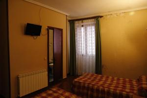 a bedroom with a bed and a window with a curtain at Pension Iberia in Llanes