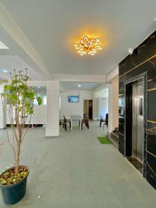 a lobby with a potted plant and a chandelier at Joy Suites and Hostel in Pune