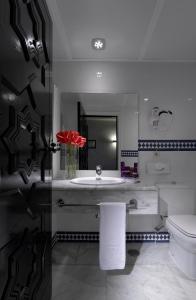 a bathroom with a sink and a toilet and a mirror at Parador de Carmona in Carmona