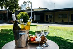 a table with two bottles and two glasses of wine at High Street Motor Inn & Steakhouse in Stanthorpe