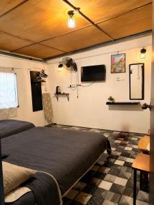 two beds in a room with a checkered floor at SABAYA HOMESTAY in Balik Pulau