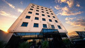 a tall white building with windows on top of it at BAZ Hotel Airport Road in Baghdād