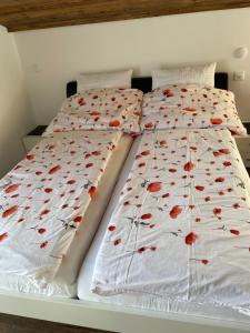 two beds with red flowers on the sheets at Haus Rosa in Zermatt