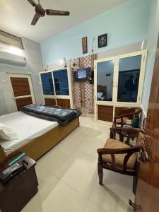 a bedroom with a bed and a chair in it at RAMRAJ GUEST House in Ayodhya