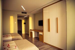 a bedroom with a bed and a desk and a television at Hotel Bologna in Vlorë