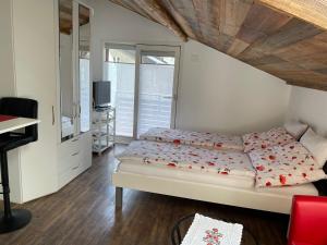 a bedroom with a bed and a desk and a television at Haus Rosa in Zermatt
