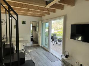 a living room with a sliding glass door to a patio at mytinyhome in Vétroz