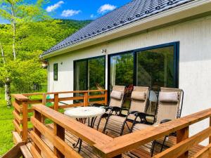 a deck with chairs and a table on a house at tocoro. Mt. Fuji Mutsuki in Fujikawaguchiko