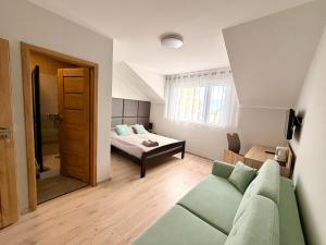 a living room with a couch and a bedroom at Willa Dominik 2 in Jastarnia