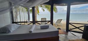 a bedroom with a bed and a view of the beach at Lauiula Beach Club in Pu‘apu‘a