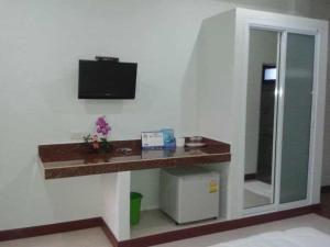 a room with a desk with a television on a wall at N-Joy Place in Surin +59 photos