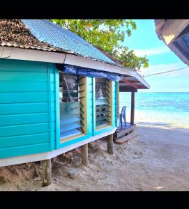 a blue shack on the beach near the ocean at Lauiula Beach Club in Pu‘apu‘a +4 photos