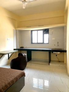 a room with a desk and a couch in a room at Joy Suites and Hostel in Pune