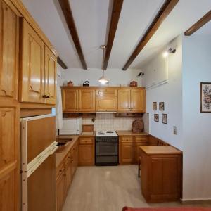 a kitchen with wooden cabinets and a stove top oven at Chios Studios Kalamari in Vrontádos