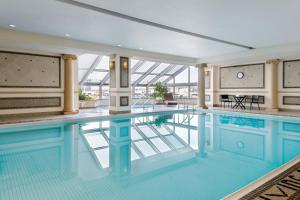 a swimming pool in a building with a glass ceiling at Sheraton Gateway Hotel in Toronto International Airport in Mississauga
