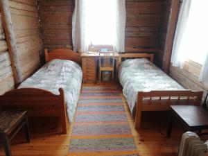a bedroom with two beds and a desk and a table at Yläpihan Tila in Valtimo