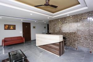 a lobby with a red couch and a ceiling fan at RAMRAJ GUEST House in Ayodhya