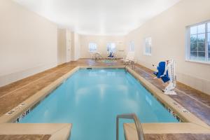 a swimming pool with blue water in a room at Microtel Inn & Suites by Wyndham Perry in Perry