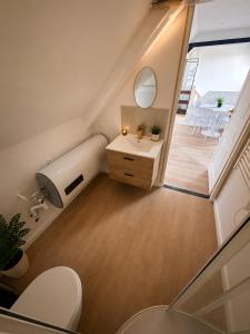 an attic bathroom with a toilet and a sink at Le Nuage - Vidéoprojecteur - Terrasse - 5min Gare in Ploumagoar