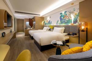 a hotel room with two beds and a couch at mango crystal hotel in Haikou