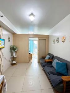 a living room with a couch and a television at Sea Residences Sunset Point in Manila