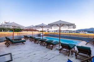 a swimming pool with lounge chairs and umbrellas at Vila Naço Ksamil in Ksamil