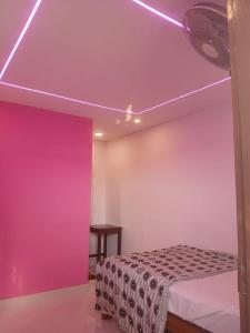 a bedroom with a bed with a purple lighting at Dolphin beach in Varkala +32 photos