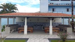 a pavilion with tables and chairs on a patio at Ubatuba Casa Condomínio Sans Souci 707-14 in Ubatuba