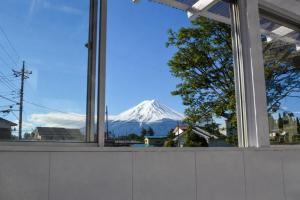 a view of a snow covered mountain through a window at tocoro. Mt. Fuji Hazuki in Fujikawaguchiko