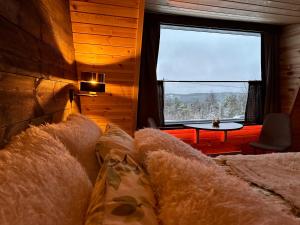 a room with a couch and a window and a table at Jättiläisenmaa in Paltamo