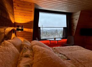 a bedroom with a bed and a large window at Jättiläisenmaa in Paltamo