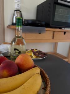 a basket of fruit sitting on a table with a bottle at Leros 'Sundown' Guest house in Gourna