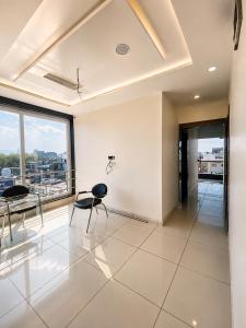 a room with two chairs and a table and windows at Hotel Tree in Hisār